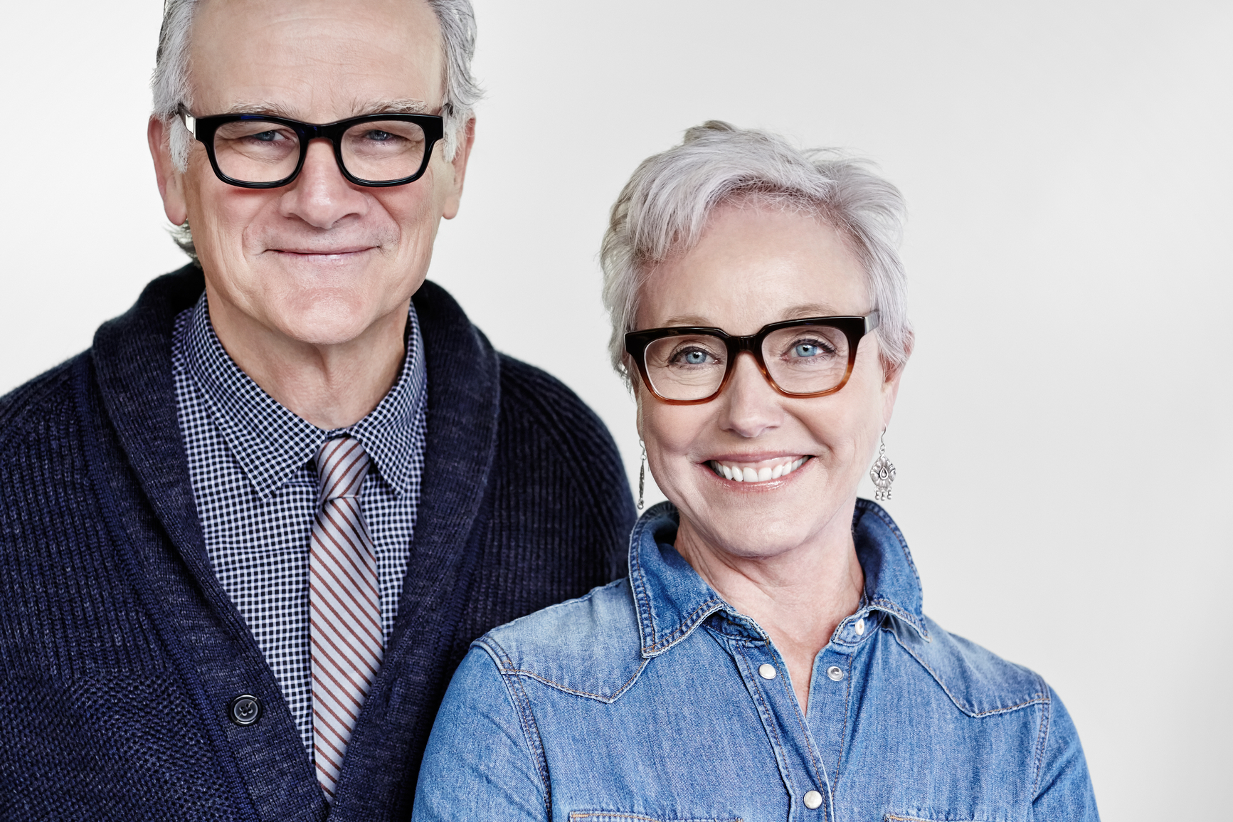 A mature couple wearing dark framed glasses