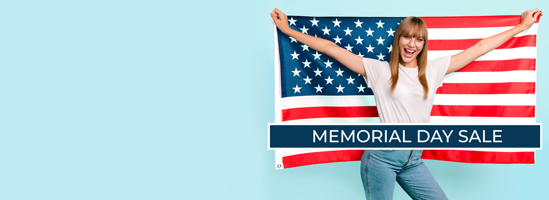 Text: Memorial Day Sale Photo: Woman holding American flag behind her wearing jeans, a white t shirt and eyeglasses