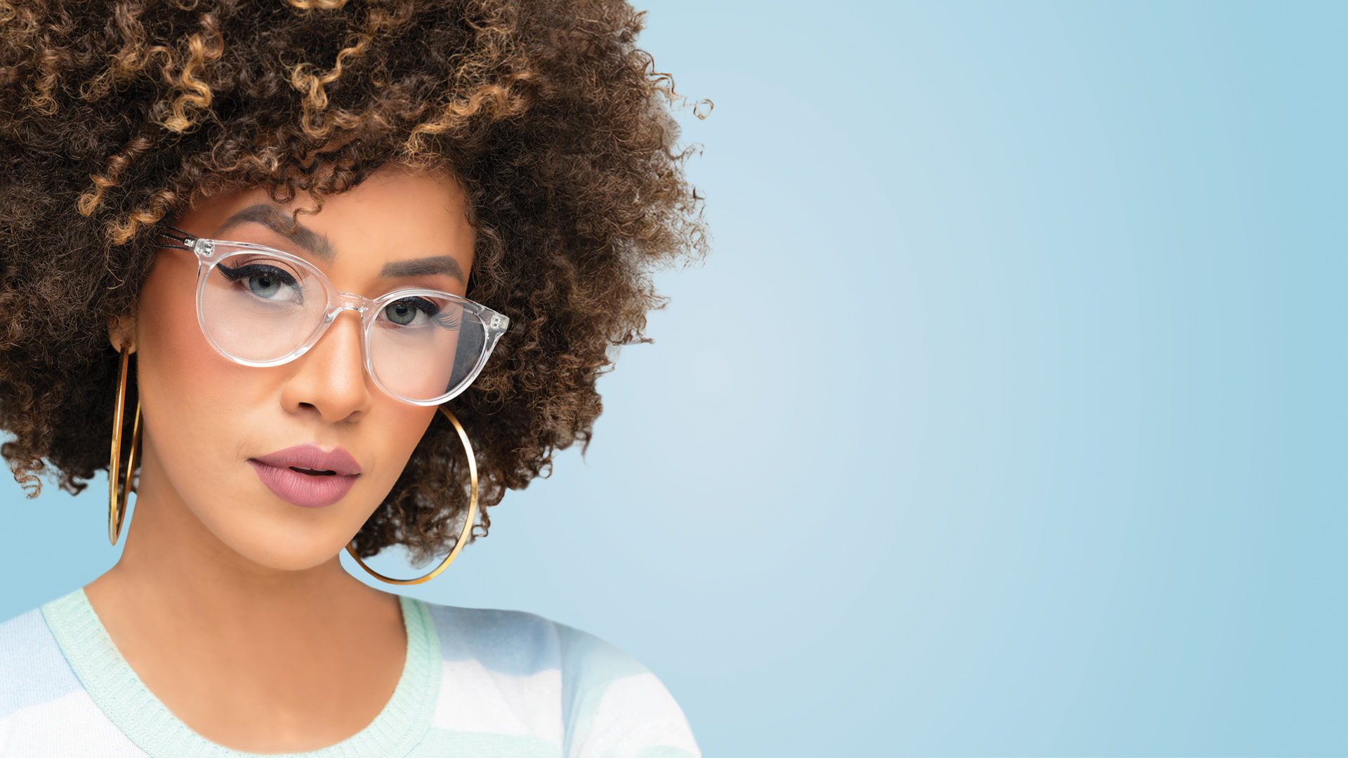 A person with curly hair wearing glasses
