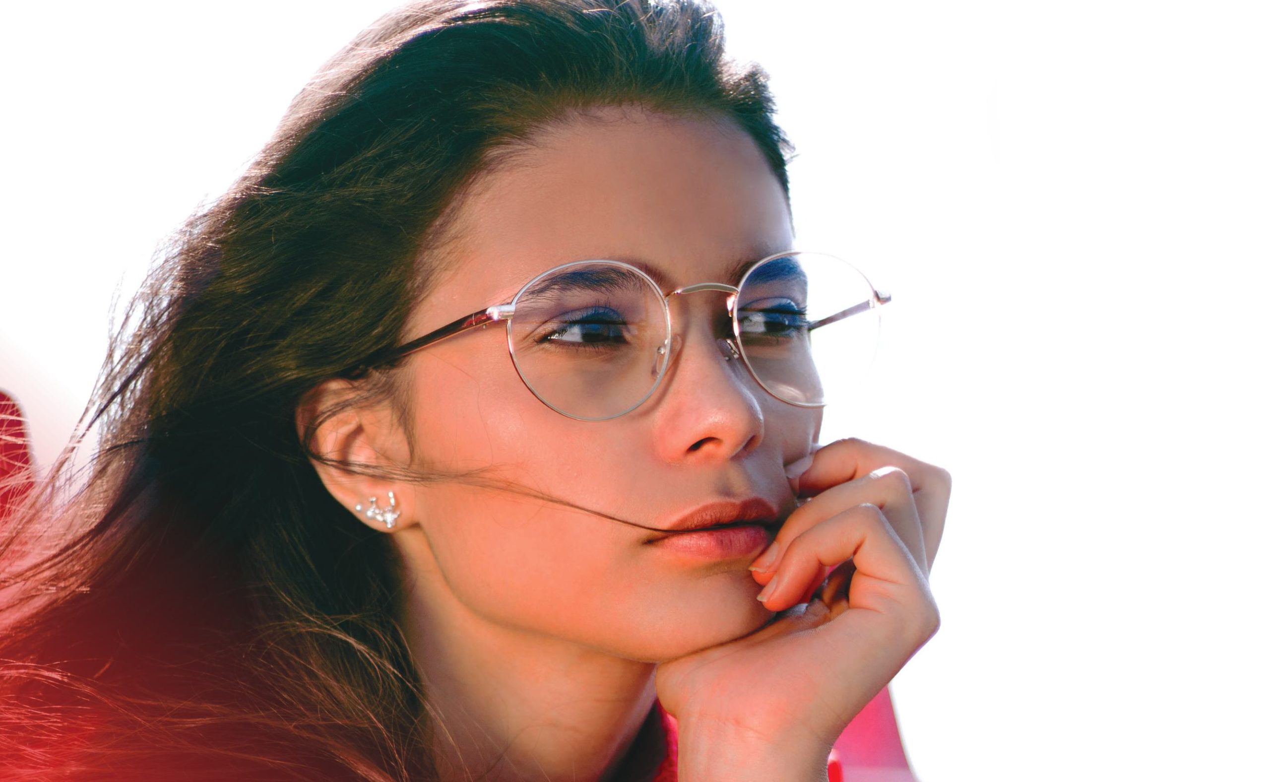 Brunette woman wearing a red sweater and eyeglasses.