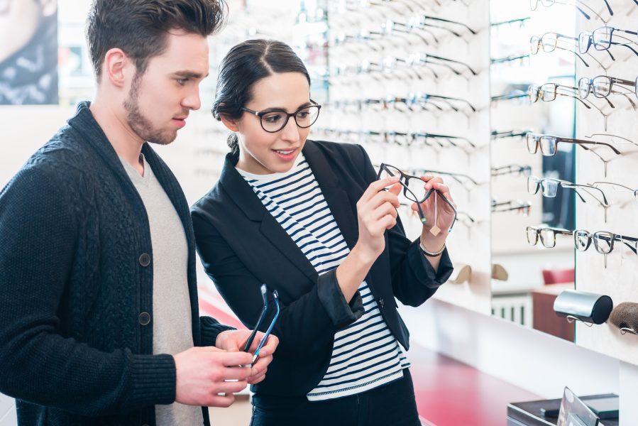man and woman looking at eyeglasses